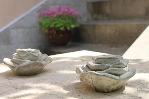 two stone bowls sitting on a table with a plant at Orange House in the Old Town Plovdiv in Plovdiv