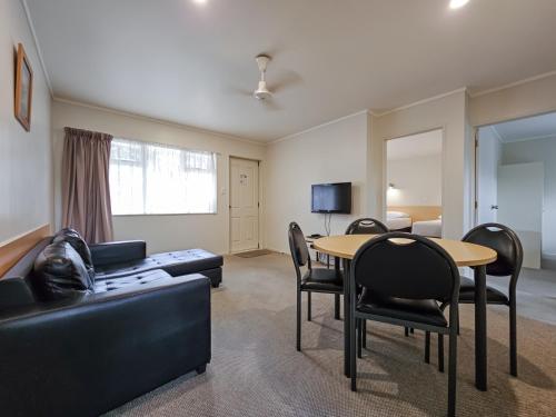 a living room with a couch and a table and chairs at Captain Cook Motor Lodge in Gisborne