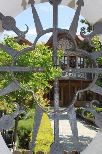 a metal gate with a building in the background at Orange House in the Old Town Plovdiv in Plovdiv