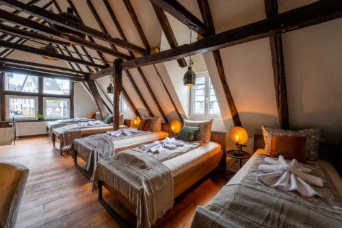 3 camas en una habitación con suelo de madera en Haus zum Ring en Adenau