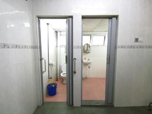 a bathroom with a door open to a toilet at Cosy Homestay Ulu Tiram in Ulu Tiram