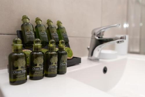 a group of bottles sitting on a counter next to a sink at Lovely 2-bedroom apartment with a city view (F10) in Piraeus