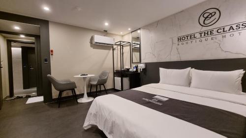 a hotel room with a bed and a table and chairs at Hotel The Classic in Ulsan