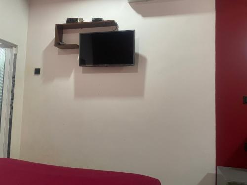 een flatscreen-tv op een witte muur bij Saga Homestay in Kurundankulama