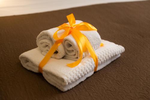 a pile of towels with an orange ribbon on them at Historico Loft & Rooms Palazzo Adragna XIX in Trapani