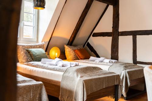 two beds in a room with two tables and two chairs at Haus zum Ring in Adenau
