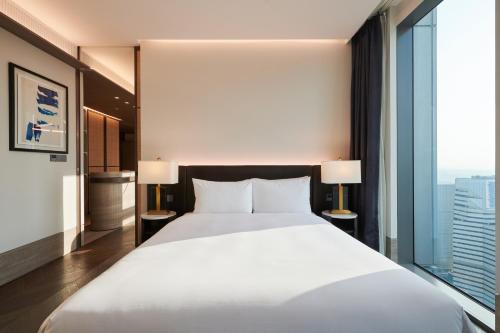 a bedroom with a white bed and a large window at Nine Tree Premier ROKAUS Hotel Seoul Yongsan in Seoul