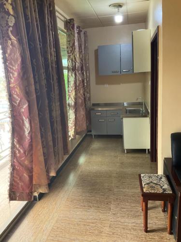 a room with a kitchen with a table and curtains at ROYAL HOTEL in Juba