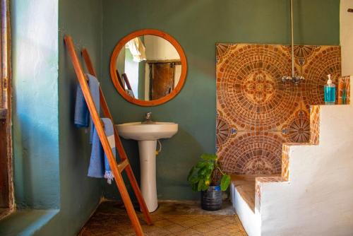 a bathroom with a sink and a mirror at Firefly Boutique Lodge in Bagamoyo