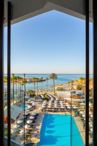 a view of the pool and beach from the balcony of a resort at Pavlo Napa Beach Hotel in Ayia Napa