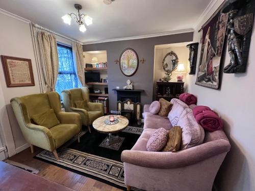 a living room with two couches and a table at Glastonbury Rose Cottage - Magical Victorian Town Centre Stay in Glastonbury