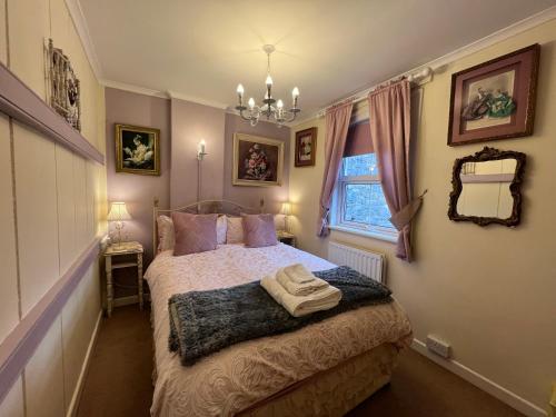 1 dormitorio con cama y espejo en la pared en Glastonbury Rose Cottage en Glastonbury