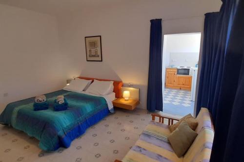 een slaapkamer met een bed, een bank en een raam bij Villa Bronja Superior Airconditioned Studio apartment in Xlendi in Xlendi