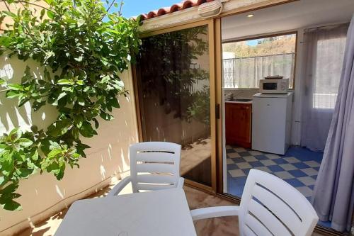 a balcony with a table and chairs and a kitchen at Villa Bronja Superior Airconditioned Studio apartment in Xlendi in Xlendi