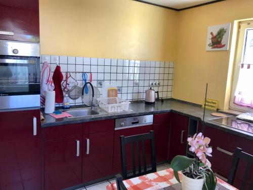 a kitchen with red cabinets and a sink at JUNA in Karlsruhe