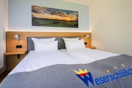 ein Schlafzimmer mit einem großen weißen Bett mit einem Schild darauf in der Unterkunft Hotel Weserschlösschen in Nienburg
