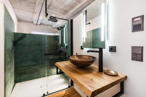 ein Badezimmer mit einem hölzernen Waschbecken und einer Glasdusche in der Unterkunft Goldliebe in Konstanz