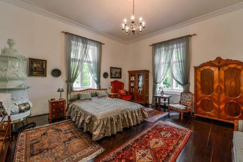 a bedroom with a bed and a chandelier at Prónay-kastély in Alsópetény