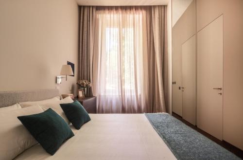 a bedroom with a large bed with a window at Sant'Ambrogio Luxury Apartment R&R in Milan