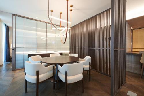 a dining room with a table and white chairs at Nine Tree Premier ROKAUS Hotel Seoul Yongsan in Seoul