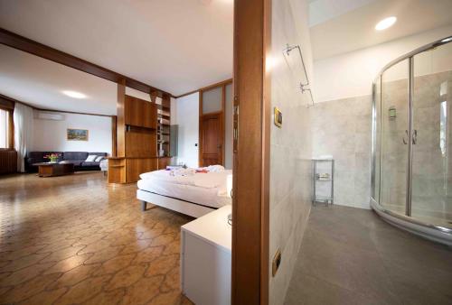 a bedroom with a bed and a living room at SunLake Hotel in Riva del Garda