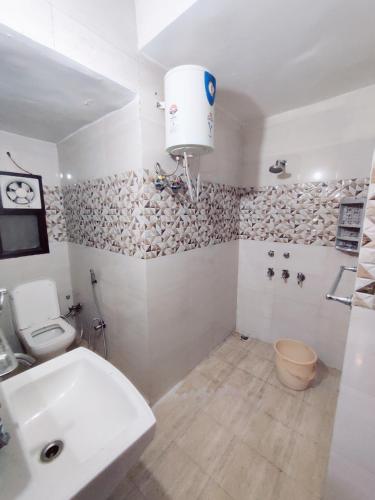 a white bathroom with a toilet and a sink at NAGPAL HOMES in New Delhi