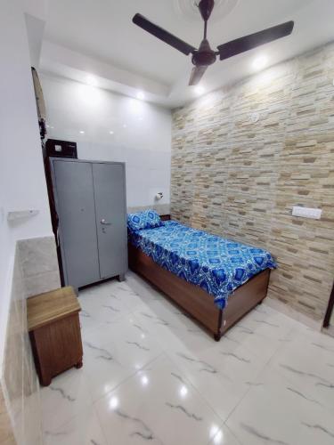 a bedroom with a bed and a brick wall at NAGPAL HOMES in New Delhi