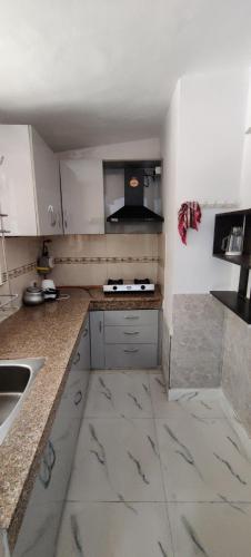 a kitchen with white cabinets and marble counter tops at NAGPAL HOMES in New Delhi