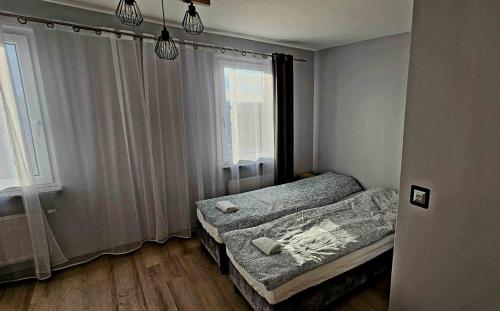 a small bedroom with two beds and a window at Route66 apartament by Karl Clim&Park in Radom