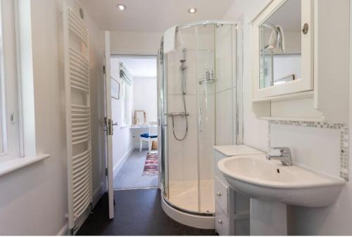 a white bathroom with a shower and a sink at The Applery, Leyburn Yorkshire Dales National Park in Leyburn