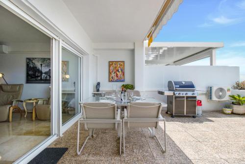 Lujoso apartamento con alucinantes vistas al golf - Iwii A 38 في مربلة: مطبخ مع طاولة وكراسي في غرفة