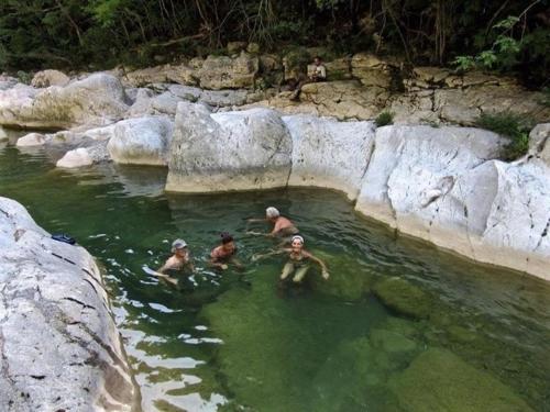 a group of people swimming in a body of water at Agriturismo Fontenuova in Saturnia