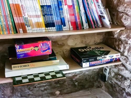 a bunch of books sitting on a shelf at Les chambres du Roc in Le Roc