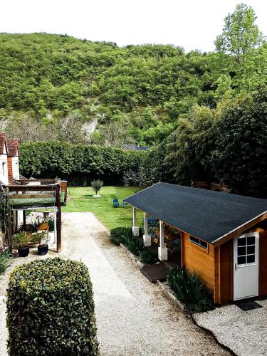 a smallshed with a black roof in a garden at Les chambres du Roc in Le Roc