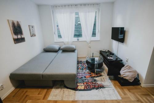 uma sala de estar com um sofá e uma mesa em Apartman Daris 2 em Sarajevo