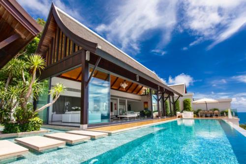 a villa with a swimming pool and a house at Kon Sang Villa in Patong Beach