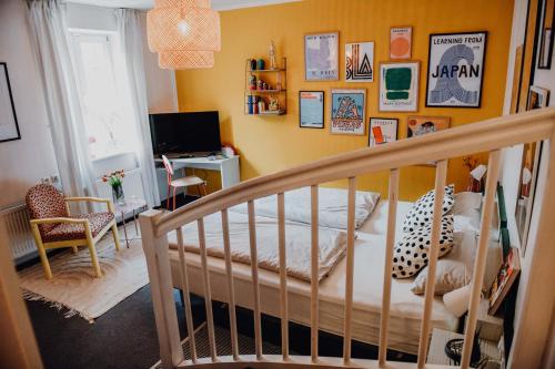 ein Schlafzimmer mit einem Kinderbett und ein Zimmer mit einem TV in der Unterkunft sleepArt room for 2 in Celle