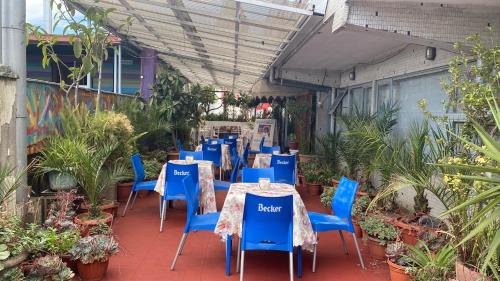 un patio con mesas azules, sillas y plantas en NEW HOTEL CRUZ DEL SUR, en Concepción