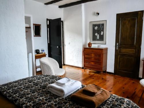 a bedroom with a bed and a chair and a dresser at Les chambres du Roc in Le Roc