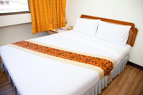 a bedroom with two beds and a window at Thumrin Hotel in Trang