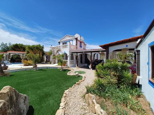 una casa grande con un patio con césped en Luxury Villa Claudia, en L'Ametlla de Mar