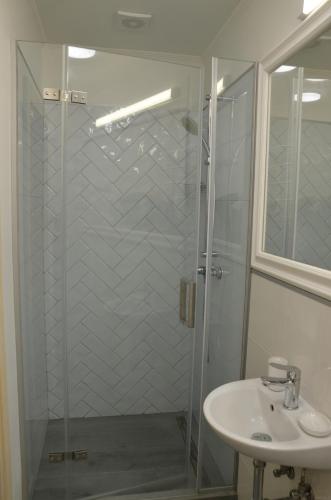 a bathroom with a glass shower and a sink at Садиба Злата хата in Urych