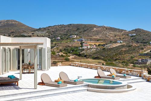 a patio with lounge chairs and a swimming pool at Syros Grace eco-Villa with Jacuzzi & Stuning Views in Ano Syros