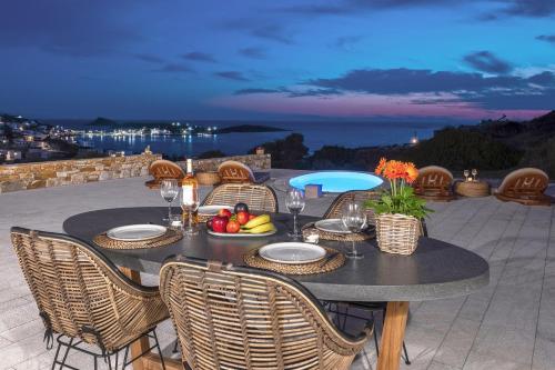 a table with a bowl of fruit on a patio at Syros Grace eco-Villa with Jacuzzi & Stuning Views in Ano Syros