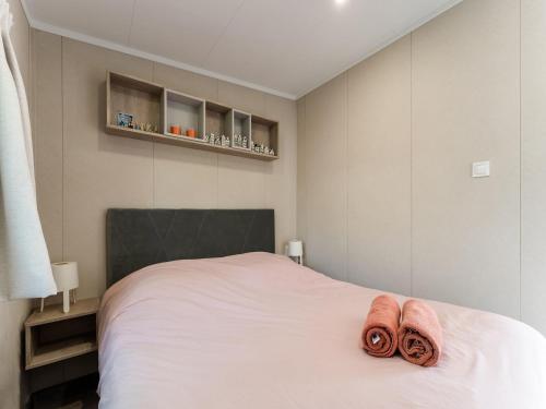 a bedroom with a bed with two towels on it at Luxury chalet near Ouddorp with garden in Goedereede