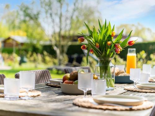 a picnic table with a vase of flowers and fruit at Luxury chalet near Ouddorp with garden in Goedereede