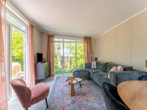 a living room with a couch and a table at Luxury chalet near Ouddorp with garden in Goedereede