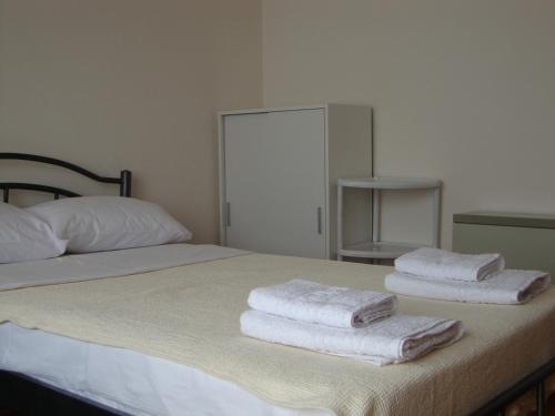 een bed met handdoeken bovenop bij Village Apartment 