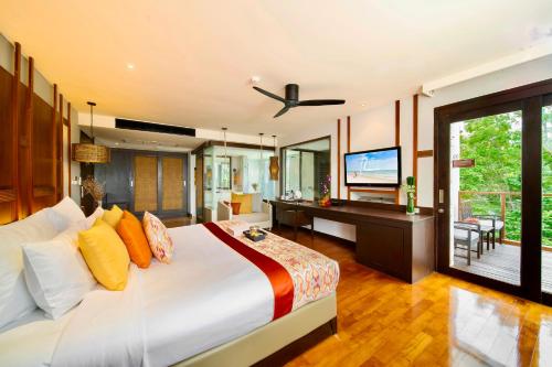 Un dormitorio con una cama grande y un televisor de pantalla plana. en The Rock Hua Hin Beachfront Spa Resort, en Hua Hin