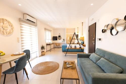 a living room with a blue couch and a table at Oreli Suite in Heraklio